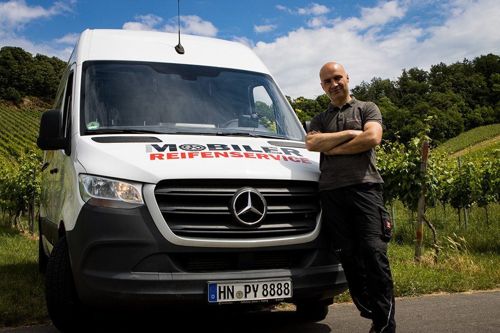 Nikolay Penev steht neben seinem beschrifteten mobilen Reifenservice-Fahrzeug